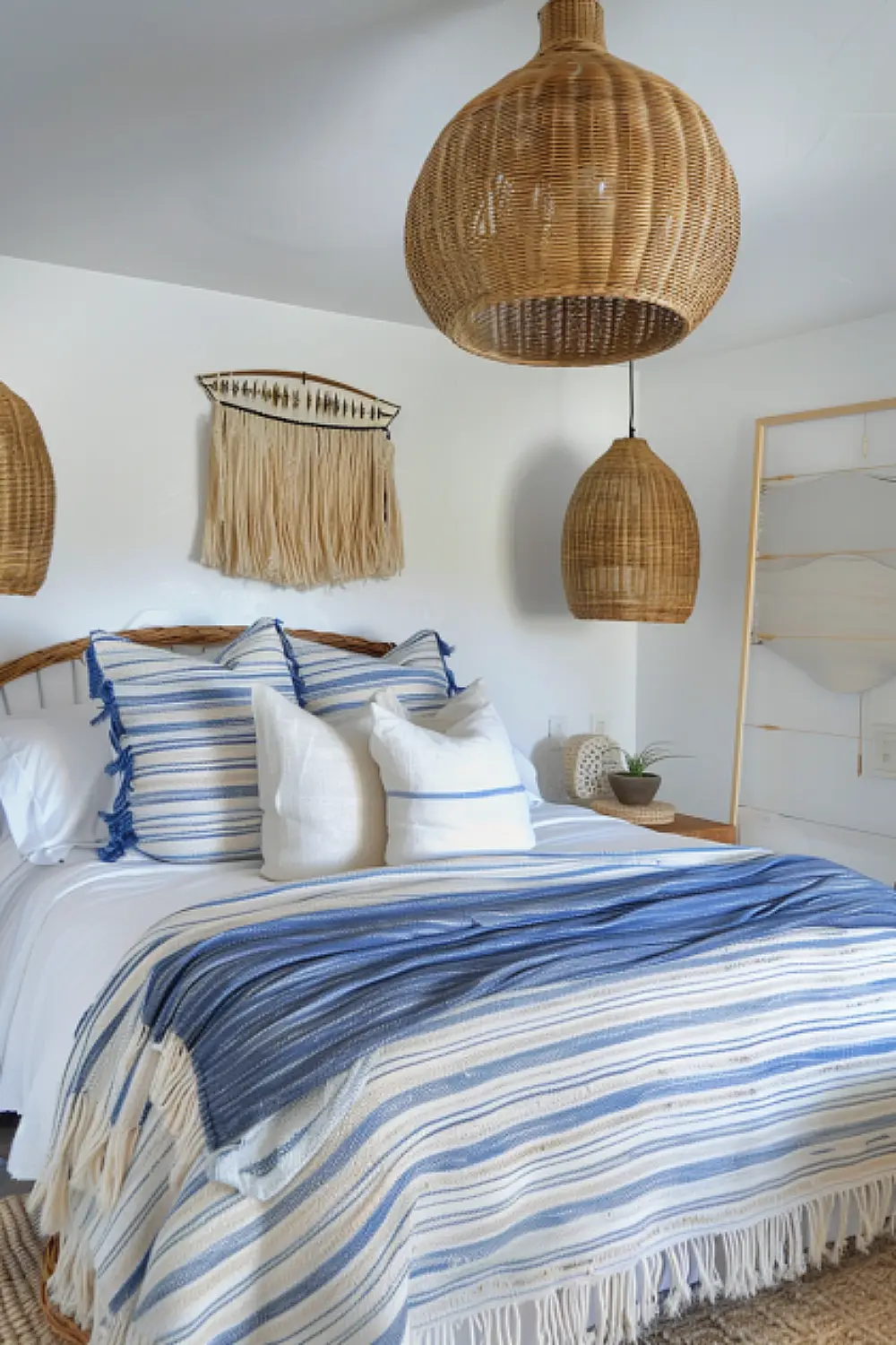 Coastal boho bedroom with woven lights and striped bedding